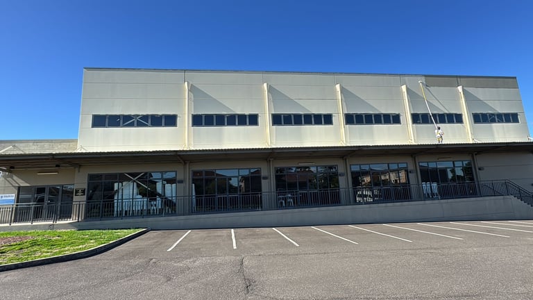 Modern commercial building with white metal facade and large windows, outdoor construction project South West Sydney