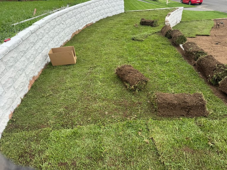 Landscaping job in progress with rolled sod grass, soil patches, and concrete edging, Sydney