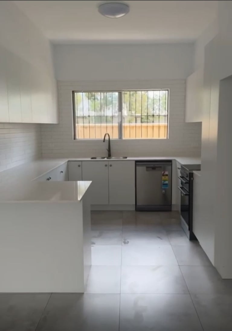 Modern minimalist kitchen with white cabinetry, stainless steel appliances, Liverpool renovation
